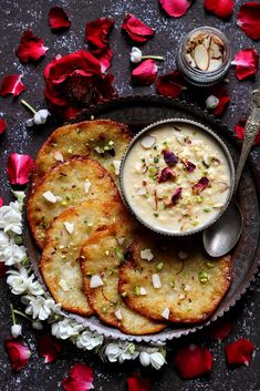 some food is on a plate with flowers and a spoon next to it that has been placed on a table