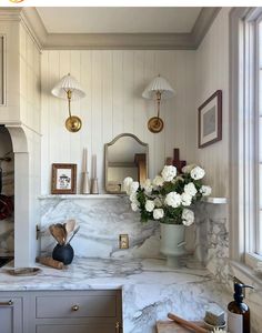 a vase filled with white flowers sitting on top of a counter