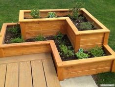 several wooden planters with plants growing in them on a decking area next to grass