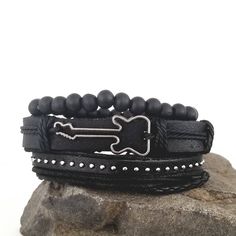 This guitar bracelet set complements your love for music. The all black bracelets are versatile and can be worn with any of your outfits. You can wear the bracelets together as a set or each one separately to create a different everyday. Every set is handmade with care. Product Information *Set comes with 3 bracelets *Material: leather/PU leather *Metals Type: alloy *Clasp Type: sliding knots *Adjustable Length: around 7 - 8.5 inches Black Band Wristband For Concerts, Casual Black Bracelets For Festival, Casual Black Wristband For Festival, Black Rock Style Bracelet For Gift, Black Rock Wristband For Concerts, Black Rock Style Wristband As Gift, Black Rock Style Wristband For Concerts, Adjustable Punk Leather Band Bracelet, Adjustable Black Band Bracelet For Festivals