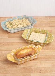 three glass dishes filled with food on top of a wooden table