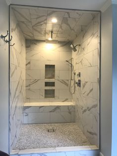 an empty shower stall in a bathroom with marble tile