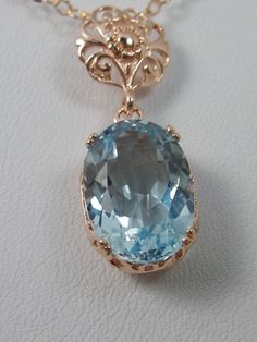 Natural Topaz Pendant Necklace, blue topaz pendant, with a natural blue topaz oval stone set in floral rose gold filigree, 4 prongs hold the gem in place, Silver Embrace Jewelry Elegant Oval Blue Topaz Necklace, Elegant Oval Topaz Necklace, Elegant Topaz Oval Pendant Necklaces, Elegant Topaz Oval Pendant Necklace, Elegant Oval Pendant Topaz Necklace, Elegant Oval Pendant Topaz Jewelry, Fine Jewelry In Rose Gold With Blue Topaz, Elegant Formal Topaz Necklaces, Elegant Oval Pendant Jewelry With Blue Topaz