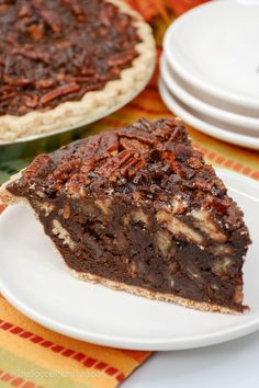 a slice of pecan pie on a plate with another pie in the back ground