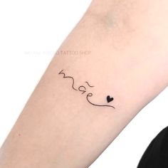 a woman's arm with a small wave tattoo on it