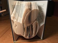 an open book with pages folded in the shape of a human head