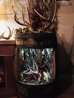 a wooden barrel filled with lots of antlers and other things on top of it