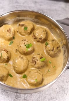 a metal pan filled with meatballs covered in gravy