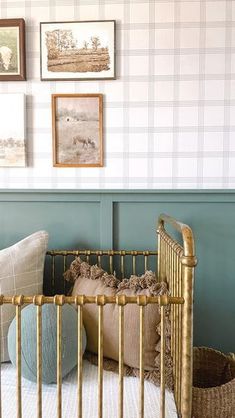 a baby crib with pillows and pictures on the wall