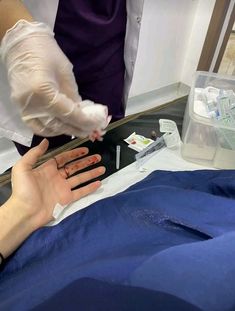 a person in a hospital bed getting their nails brushed by someone with white gloves on