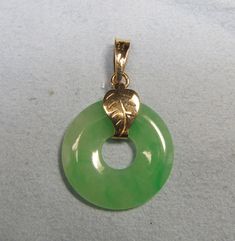 This pendant is a nice piece of circular green jade with 18Kt yellow gold leaf-motif band an bail. The jade measures 22 millimeters and the height of the bail is 10 millimeters. Onyx Signet Ring, Antique Filigree, Leaf Motif, Skull And Crossbones, Filigree Ring, Green Jade, Jade Green, 14kt Gold, Signet Ring