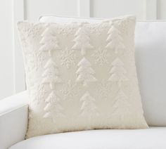 a white christmas pillow sitting on top of a couch