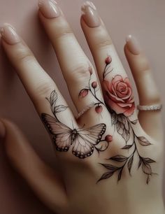 a woman's hand with tattoos on it and a rose tattooed on the ring