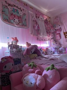 there are many stuffed animals on the pink bed in this girls'room with hello kitty decorations