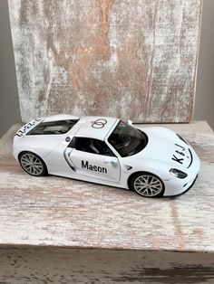 a white toy car sitting on top of a wooden table