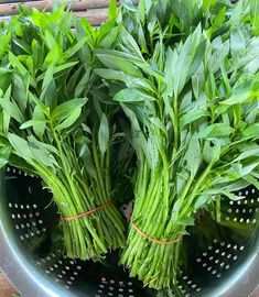 some green herbs are in a colander