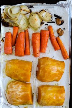 carrots, onions and other vegetables on a baking sheet