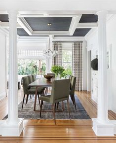 a dining room table with chairs and a chandelier hanging from the ceiling above it