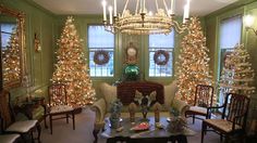 a living room filled with furniture and christmas trees