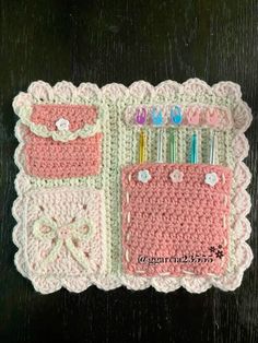 a crocheted pink and white purse with toothbrushes in it on a table