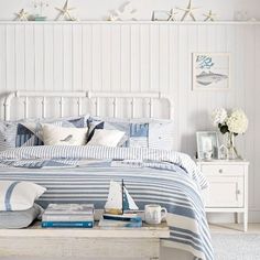 a bed with blue and white striped comforter next to a wall mounted fish on the wall