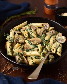 pasta with mushrooms and spinach in a black bowl