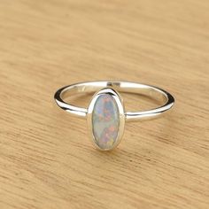 Silver Opal Ring With Round Band For Formal Occasions, Adjustable Oval Opal Ring In White Gold, Formal Silver Opal Rings, Silver Stackable Opal Ring, Silver Opal Birthstone Ring, Silver Solitaire Opal Ring In Fine Jewelry Style, Oval Opal Stackable Rings, Silver Oval Opal Birthstone Ring, Silver Opal Birthstone Ring Oval Shape