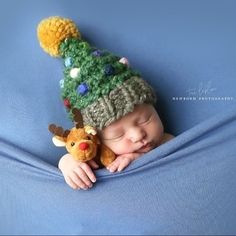 a newborn baby wearing a knitted christmas hat