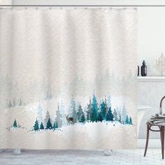 a bathroom with a shower curtain that has trees on it and snow in the background