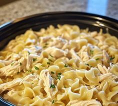 a bowl filled with pasta and chicken on top of a table