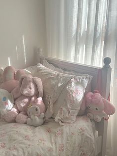 a bed with pink and white stuffed animals on it