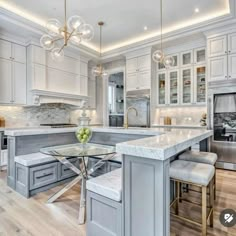 a large kitchen with white cabinets and marble counter tops, along with an island in the middle