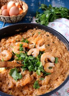 a pan filled with rice and shrimp on top of a table