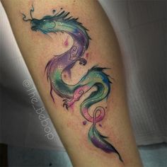 a colorful dragon tattoo on the right arm and leg, with watercolors all over it