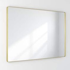 a white wall with a gold framed mirror