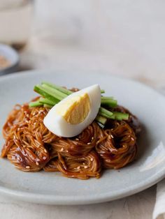 a plate with noodles and an egg on top