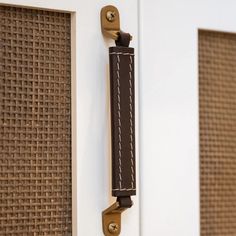 a close up of a door handle on the side of a building with woven fabric behind it