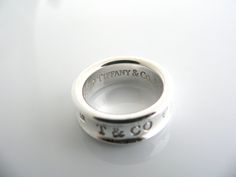 Overview:Offered for sale is a classic and gorgeous 1837 Tiffany and Co. Sterling Silver ring. Looks very feminine and pretty on the fingers, this ring is surely one that you will use over and over again. It is very versatile, and comfortable to wear. Easily sizable due to the way it is made. Great piece to start or add to your Tiffany collection. The ring is fully hallmarked and is guaranteed to be 100% authentic.Wonderful present for yourself or anyone you love! Will surely delight!Particulars Designer Rings With Polished Finish For Anniversary, Luxury Silver Rings With Classic Design, Luxury Engraved Sterling Silver Ring With Round Band, Luxury Engraved Sterling Silver Ring, Luxury Sterling Silver Engraved Ring, Designer Engraved Rings For Gifts, Designer Engraved Ring For Gift, Designer Engraved Ring For Gifting, Designer Engraved Ring As A Gift