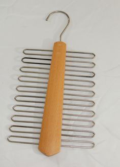 a wooden hanger with metal bars attached to it on a white tablecloth background