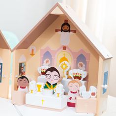 a paper doll house with people in it and an image of jesus on the wall