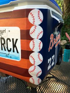 an ice chest with baseballs painted on it