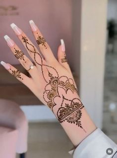 a woman's hand with henna tattoos on it