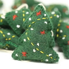 small green felt christmas trees with red and yellow stars on them, sitting next to each other