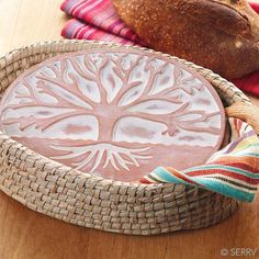 a bowl with a tree design on it sitting next to some bread and other items