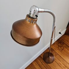 a lamp that is on the side of a wall next to a wooden flooring