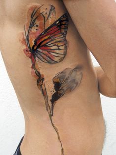 a woman with a butterfly tattoo on her stomach