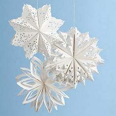 three white paper snowflakes hanging from strings