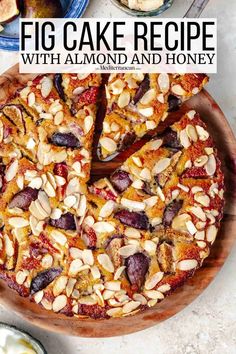 a cake with almonds and honey is on a wooden platter next to other desserts