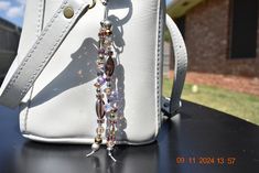 a white purse with a chain hanging from it's side on top of a table