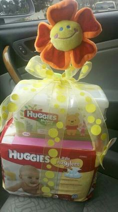 a stuffed animal sitting on top of a car seat next to boxes of diapers